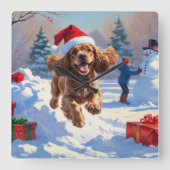 Cocker Spaniel läuft in Schnee mit Weihnachtshut Quadratische Wanduhr (Vorderseite)