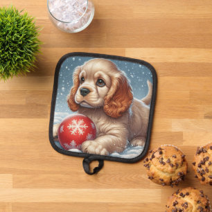 Cocker Spaniel Welpe auf Schnee mit einer Kugel Topflappen