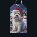 Coton De Tulear Winter Wonderland Christmas Joy Geschenkanhänger<br><div class="desc">Dieses festliche Design spiegelt den fröhlichen Geist der Urlaubssaison wider und besticht durch ein hübsches Jungtier mit einer Weihnachtsmannmütze. Der Hund ist eingebettet in ein winterliches Wunderland, mit einem Schneemann, einem dekorierten Weihnachtsbaum und wunderschön verpackten Geschenken. Schneeflocken fallen sanft ab und geben der Szene eine magische Touch, während die lebhaften...</div>