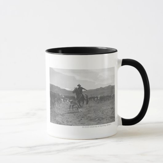 Cowboy, der ein Kalb für das Frühlingseinbrennen Tasse (Rechts)