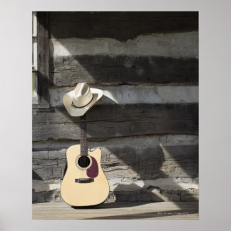 Cowboy-Hut auf Gitarre, die sich auf der Blockhütt Poster