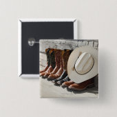 Cowboy-Hut in Reihe von Cowboy-Stiefeln außerhalb Button (Vorne & Hinten)