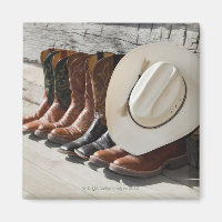 Cowboy-Hut in Reihe von Cowboy-Stiefeln außerhalb
