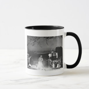 Cowboys singen und spielen um ein Lagerfeuer herum Tasse