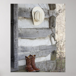 Cowboystiefel und Hut außerhalb der Blockhütte Poster