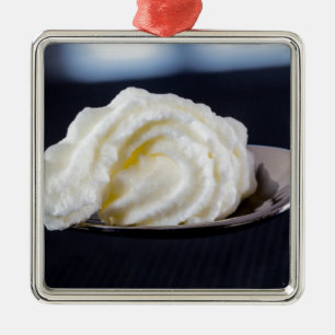 Creme auf einem Löffelmakro-Konzept Ornament Aus Metall