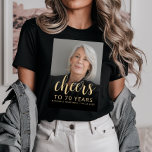 Custom Foto Cheers 70. Geburtstagsparty T-Shirt<br><div class="desc">Dieser T - Shirt der 70. Geburtstagsfeier zeigt den Ehrengast mit einem vergoldeten Textüberlagerungsstück. Das Wort "jubeln" erscheint in eleganter goldfarbener Kalligraphie-Schrift, gefolgt von "bis 70 Jahre" und dem Ehrengast und Geburtstag in serifenlosen Sans-Schriftart. Ein dunkler Bildschirm hilft, den Text-Pop zu machen. Eine tolle Art, jemanden zu feiern, der siebzig...</div>