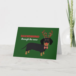 Dackel durch Schnee Niedliche Dackel Rentierhund Feiertagskarte