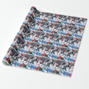 Dalmatiner läuft im Schnee mit Weihnachtsmütze Geschenkpapier