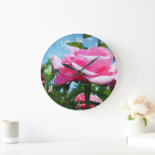Das herrliche Rosa erhob sich am blauen Himmel. Bl Große Wanduhr (Zuhause)