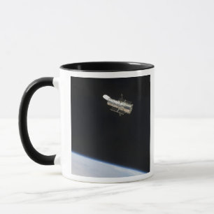 Das Hubble-Weltraumteleskop im Orbit über der Erde Tasse