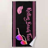 Das Strandtuch ist schwarz und rosa. (Vorderseite)