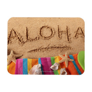 Das Wort Aloha geschrieben auf einen sandigen Magnet