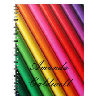 Der gefärbte Regenbogen zeichnet Notizbuch an Notizblock