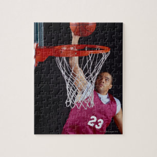 Der junge Mann macht einen Korb Puzzle
