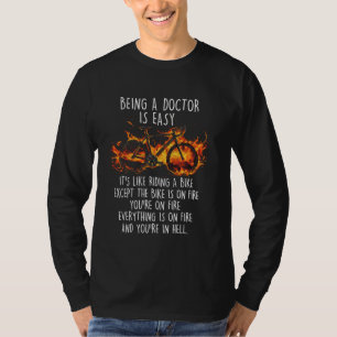 Der lustige Arzt ist ein leichtes Fahrrad am Feuer T-Shirt