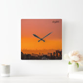 Der Sonnenuntergang über der Stadt Quadratische Wanduhr (Zuhause)