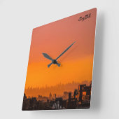 Der Sonnenuntergang über der Stadt Quadratische Wanduhr (Winkel)
