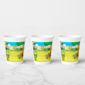 Der spielerische Junge, der in einem üppig grünen  Pappbecher