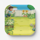 Der spielerische Junge, der in einem üppig grünen Pappteller (Vorderseite)