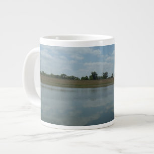 Der Wassersee spiegelt den Himmel wider, der durch Jumbo-Tasse