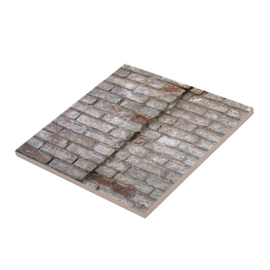 Detail einer Wand eines alten roten Backsteins mit Fliese (Seite)