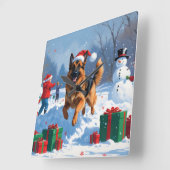 Deutscher Schäferhund läuft mit Weihnachtshut im S Quadratische Wanduhr (Winkel)