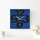 Dicke Zahlenfront an der blauen Wand Quadratische Wanduhr (Zuhause)