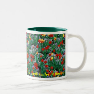 Die Erde lächelt in den Blumen - grünen Sie durc Zweifarbige Tasse