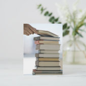 Die Hand des Mannes, die ein Buch von einem Stapel Postkarte (Stehend Vorderseite)