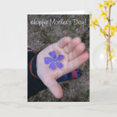 Die Hand des Muttertagkindes, das Lila Blume gibt Karte (Gelbe Blume)