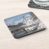 Die Kirche im Schnee mit den Alpen im Winter Getränkeuntersetzer (Linke Seite)