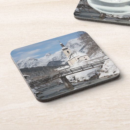 Die Kirche im Schnee mit den Alpen im Winter Getränkeuntersetzer (Linke Seite)