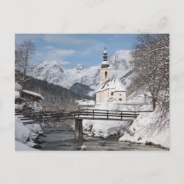 Die Kirche im Schnee mit den Alpen im Winter Postkarte