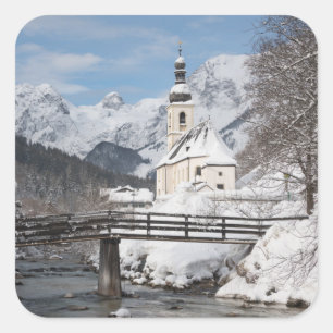 Die Kirche im Schnee mit den Alpen im Winter Quadratischer Aufkleber