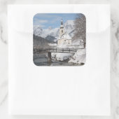 Die Kirche im Schnee mit den Alpen im Winter Quadratischer Aufkleber (Tasche)