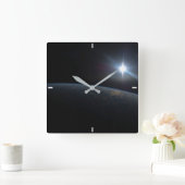 Die Sonne liegt über dem Horizont der Erde. Quadratische Wanduhr (Zuhause)