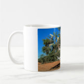 Die sonnigen Ziegen in Bäumen begrüßen die unerwar Kaffeetasse (Links)