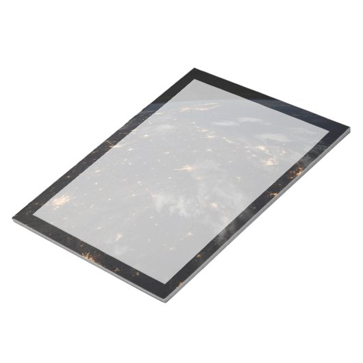 Die Stadt beleuchtet nachts auf der Erde Notizblock (angewinkelt)