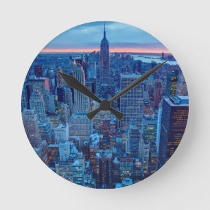 Die Wolkenkratzer von Manhattan werden beleuchtet Runde Wanduhr