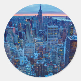 Die Wolkenkratzer von Manhattan werden beleuchtet Runder Aufkleber