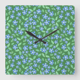 Ditsy Bright Blue Periwinkles auf grüner Flora Quadratische Wanduhr