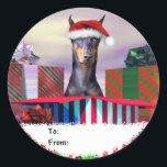 Doberman Christmas Surprise Geschenkartikel Tags Runder Aufkleber<br><div class="desc">Teilen Sie eine Urlaubserlebnis mit diesem Doberman Pinscher,  der eine Weihnachtsmannmütze trägt,  die aus einer riesigen Geschenkboxen kommt. Weihnachtskunst von Danes-R-Us.</div>