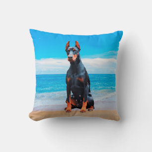 Doberman Hund sitzt am Strand Kissen