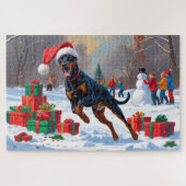 Doberman läuft im Schnee mit Weihnachtshut Puzzle (Horizontal)