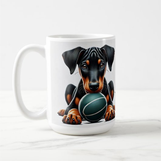 Doberman Pinscher Puppy hält einen Ball Kaffeetasse (Links)