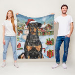 Doberman Winter Wonderland Christmas Joy Fleecedecke<br><div class="desc">Dieses festliche Design spiegelt den fröhlichen Geist der Urlaubssaison wider und besticht durch ein hübsches Jungtier mit einer Weihnachtsmannmütze. Der Hund ist eingebettet in ein winterliches Wunderland, mit einem Schneemann, einem dekorierten Weihnachtsbaum und wunderschön verpackten Geschenken. Schneeflocken fallen sanft ab und geben der Szene eine magische Touch, während die lebhaften...</div>