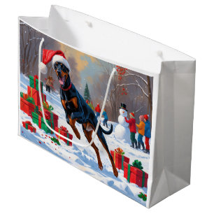 Dobermann läuft im Schnee mit Weihnachtsmütze Große Geschenktüte