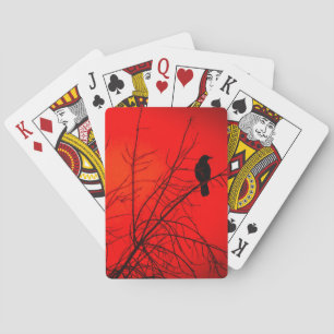 Dramatischer Krähenvogel im Baum Rotes Winterfoto Spielkarten