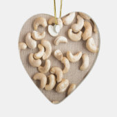 Draufsicht über rohe Acajounüsse zerstreute auf Keramikornament (Links)